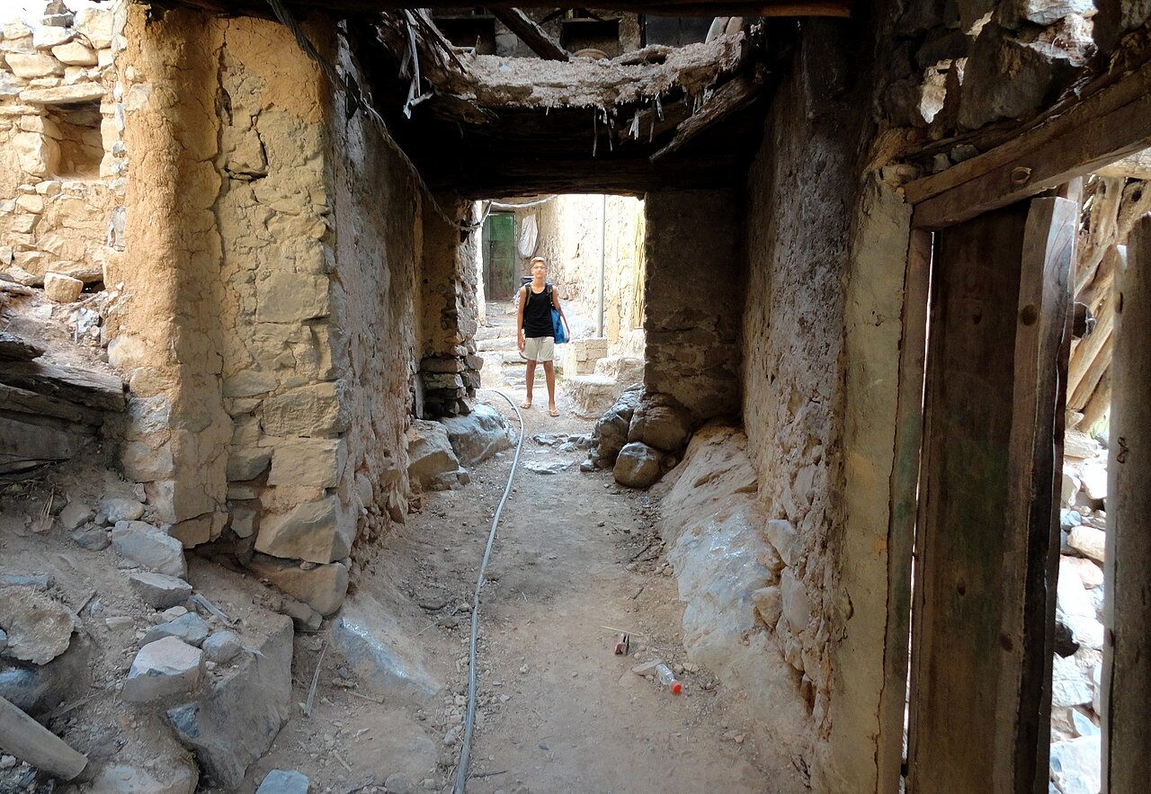 Schmale überdachte Gasse mit alten Steinmauern in Misfat al-Abriyeen